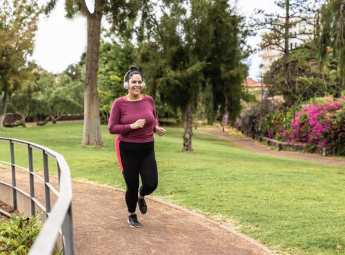 Curvy Woman Doing Jogging Routine Outdoor At City Park - Focus On Face