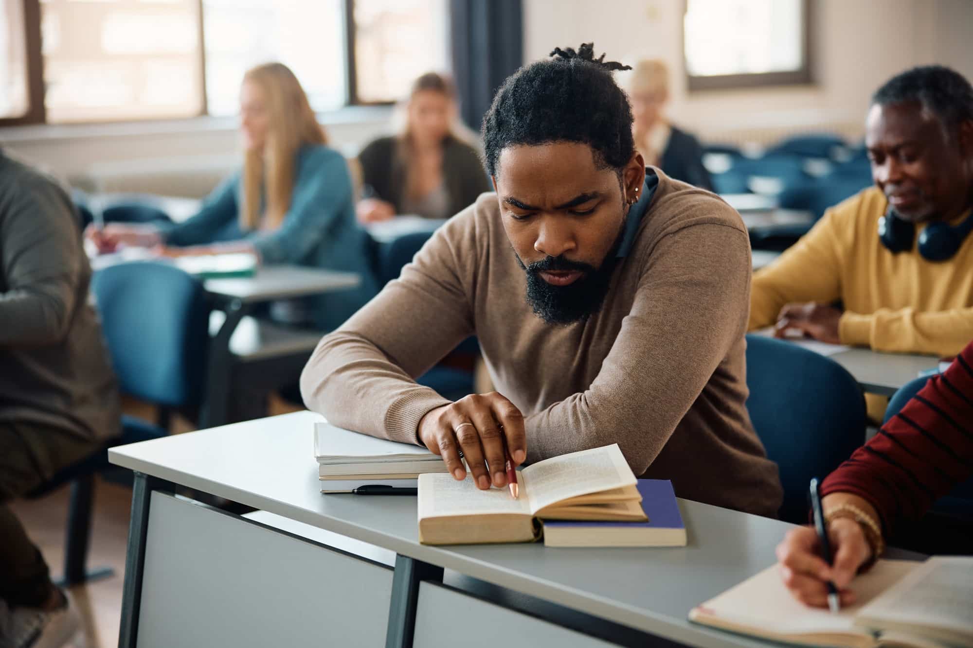 Black man studying during adult educational training course in the classroom.