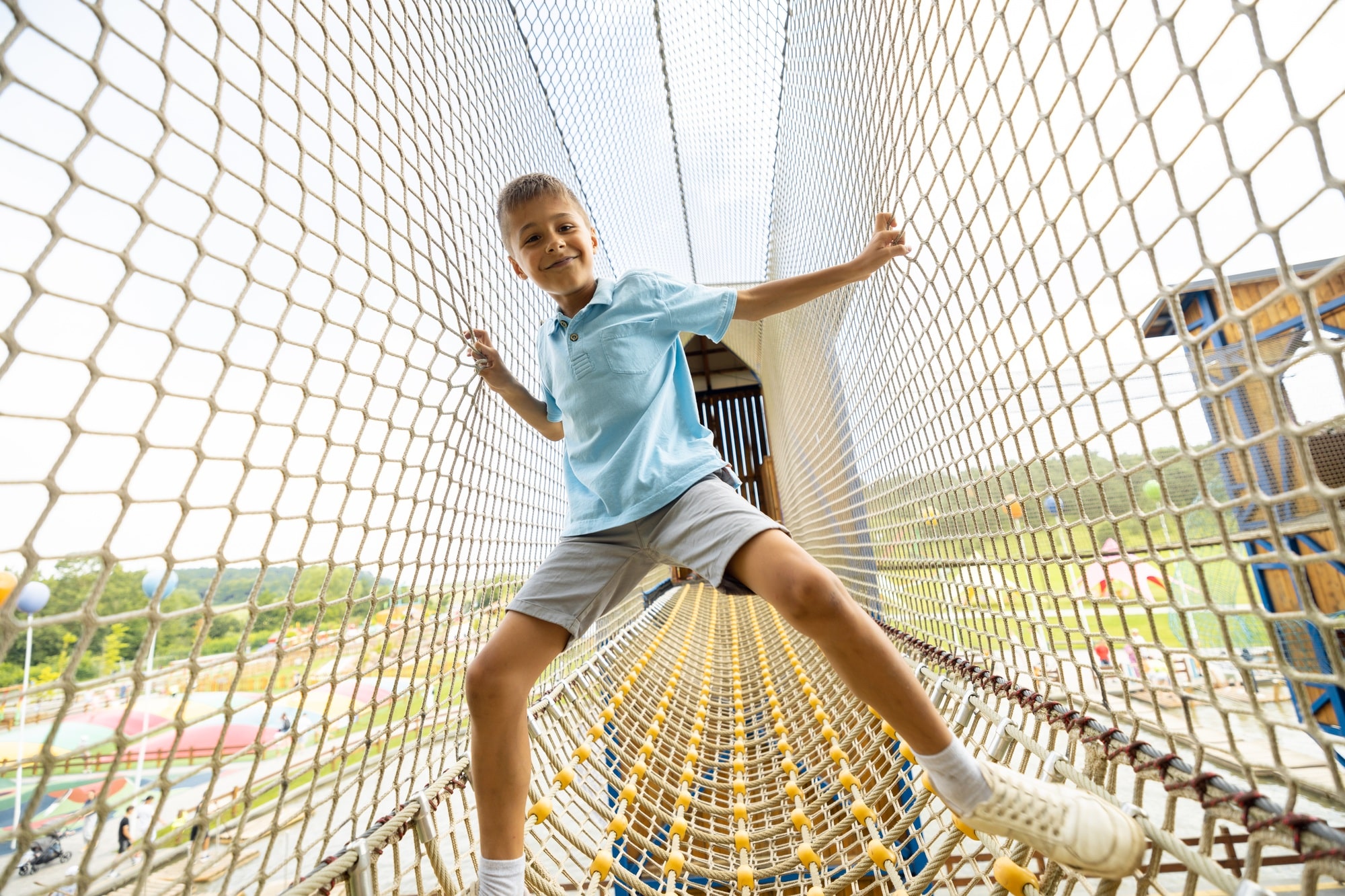 Boy climbs the nets at amusement park Boy climbs the nets at amusement park