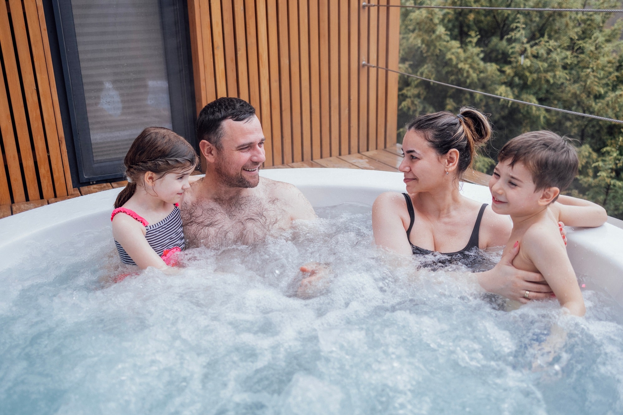 Happy family with two small children have fun in the jacuzzi Happy family with two small children have fun in the jacuzzi